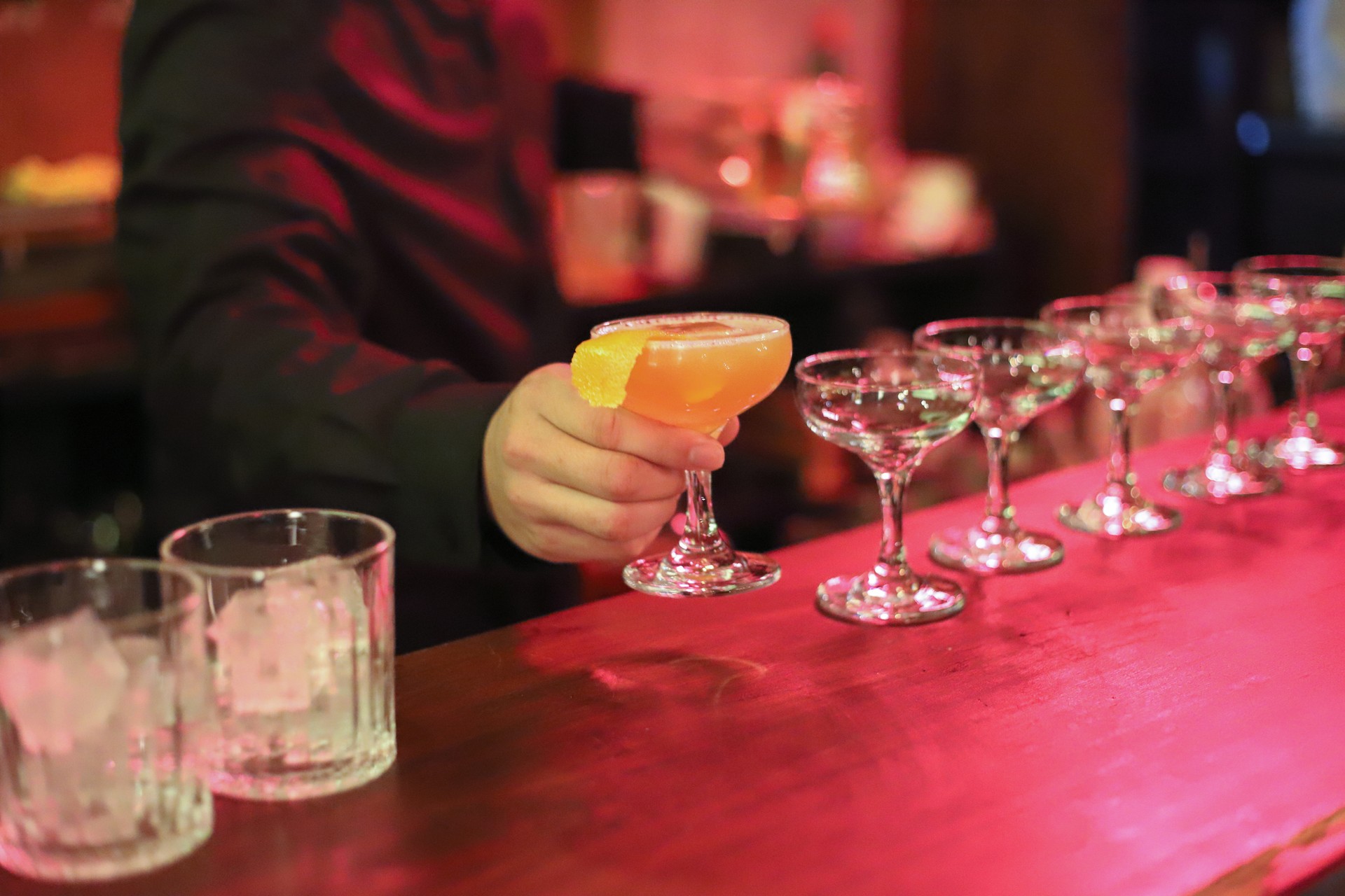 The bartender is making drinks for the guests in the nightclub.